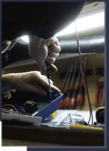 Neutronics engineer repairing industrial circuit board at electronics workbench